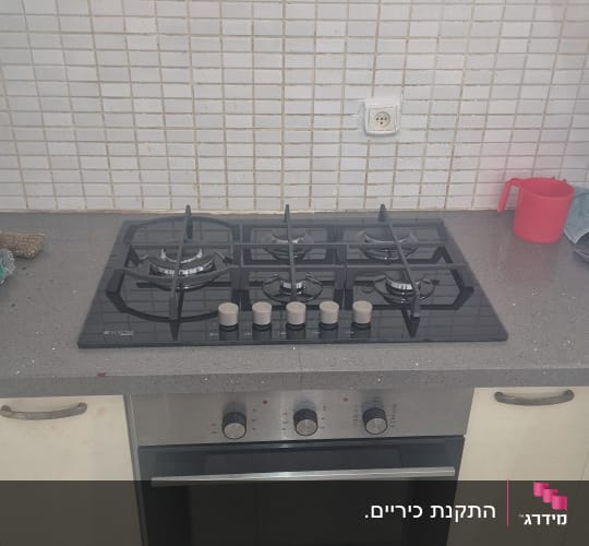כיריים ותנור במטבח עם אריחים לבנים